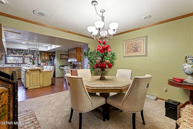 dining area featuring dark hardwood / wood-style flooring, a textured ceiling, crown molding, sink, and a notable chandelier