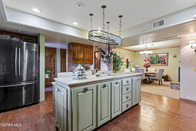 kitchen with a center island, dark wood-type flooring, decorative light fixtures, stainless steel fridge, and a notable chandelier