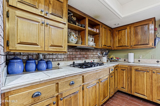 kitchen with tile countertops, dark hardwood / wood-style floors, stainless steel gas cooktop, and tasteful backsplash