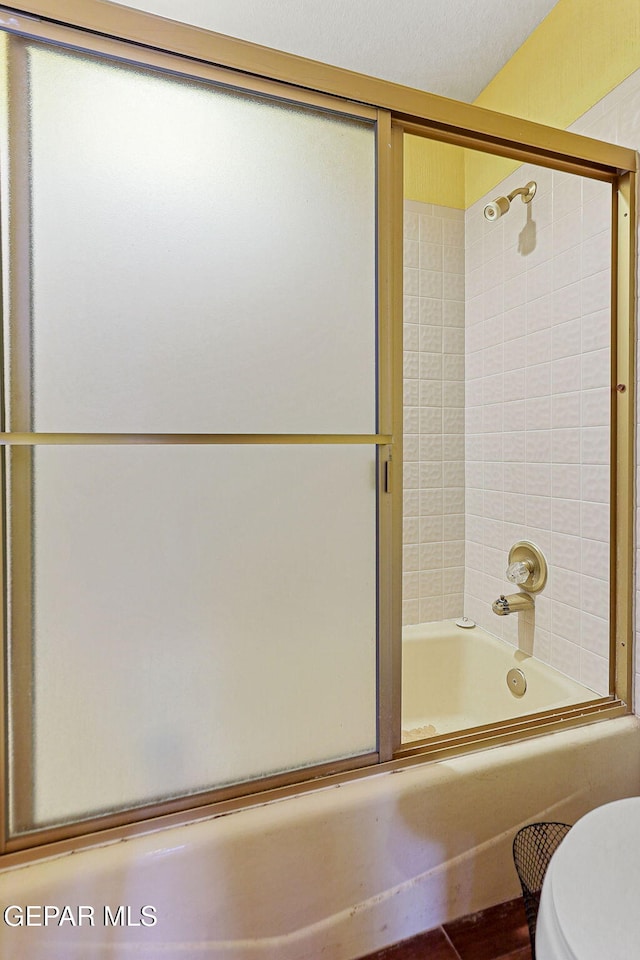 bathroom featuring toilet and enclosed tub / shower combo