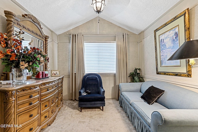 sitting room featuring a textured ceiling, light colored carpet, and vaulted ceiling