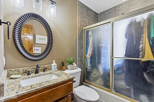 full bathroom featuring toilet, vanity, and combined bath / shower with glass door