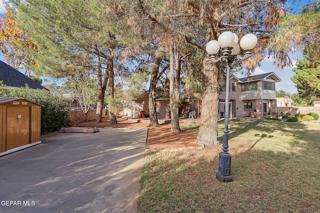 view of front of house featuring a front lawn and a storage unit