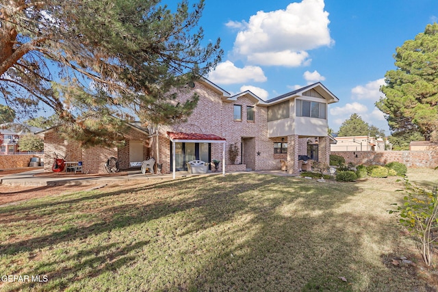 rear view of property with a yard and a patio