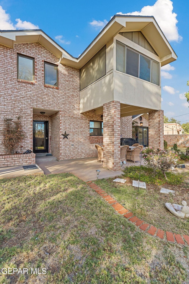 back of property featuring a yard and a patio area