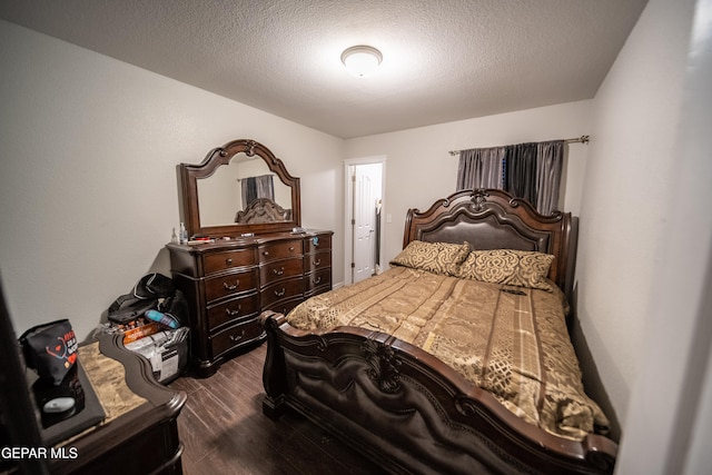 bedroom with a textured ceiling and dark hardwood / wood-style flooring