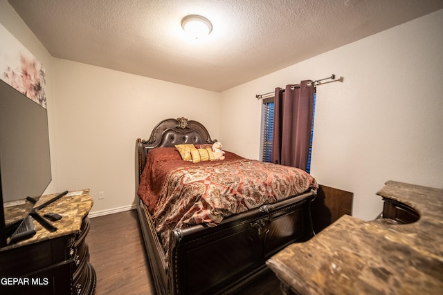 bedroom with a textured ceiling and dark hardwood / wood-style floors