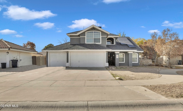 view of front property featuring solar panels and a garage