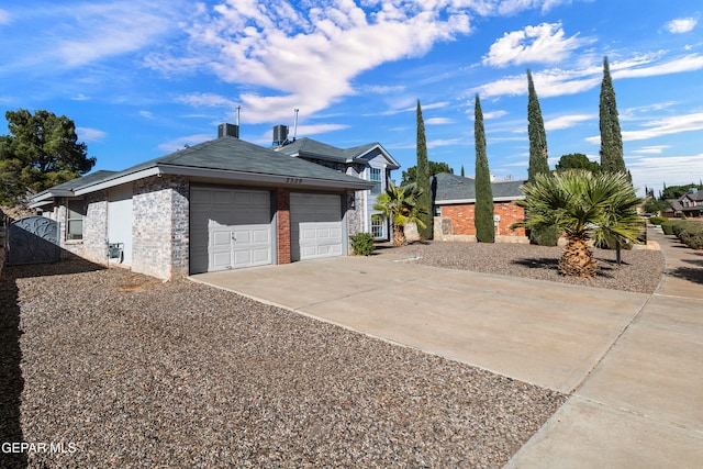 view of side of home with a garage and central air condition unit