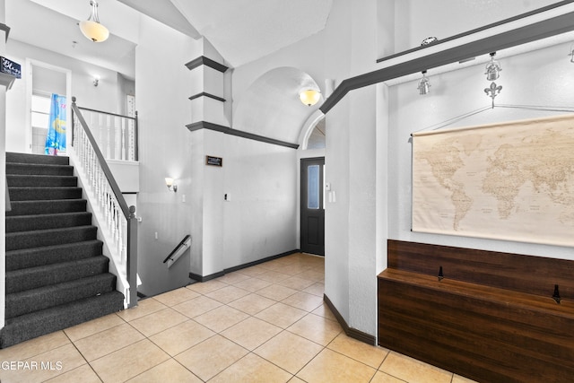 foyer with lofted ceiling and light tile patterned flooring