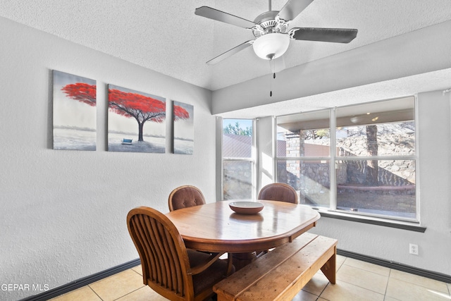 dining area featuring ceiling fan, light tile patterned floors, and a textured ceiling