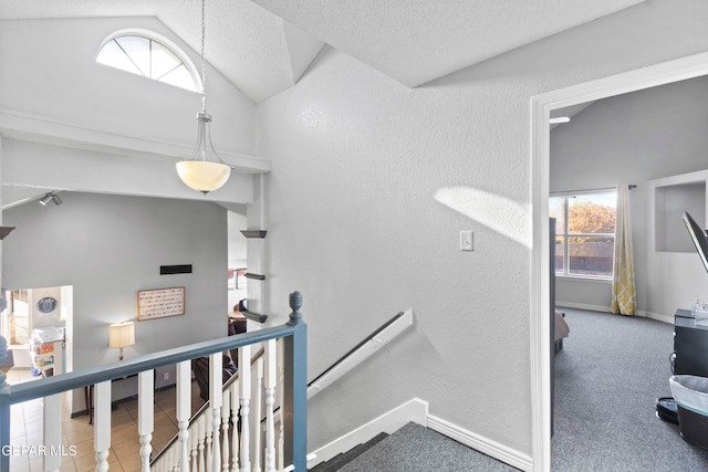 stairs with a textured ceiling, carpet floors, and lofted ceiling