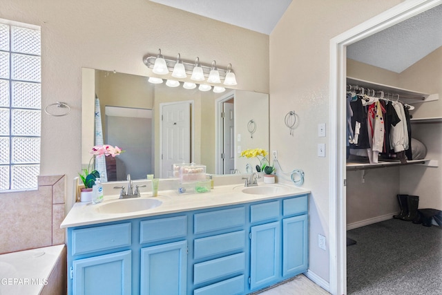 bathroom featuring a textured ceiling and vanity