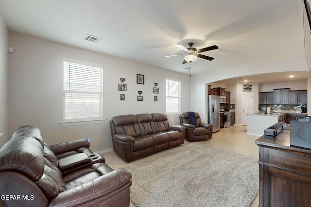 living room featuring light wood-type flooring, a wealth of natural light, and ceiling fan