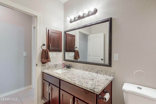 bathroom featuring tile patterned flooring, vanity, and toilet