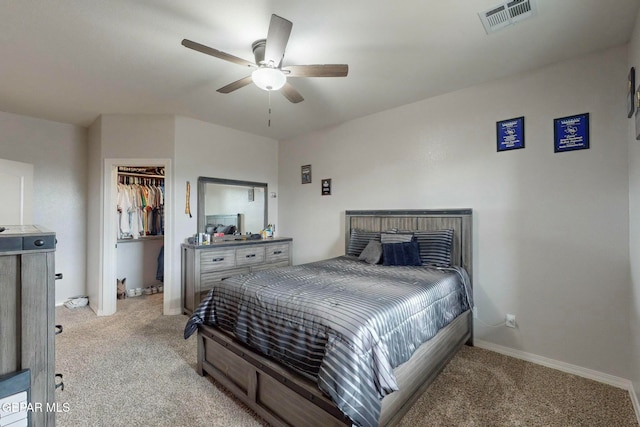 carpeted bedroom featuring ceiling fan, a spacious closet, and a closet