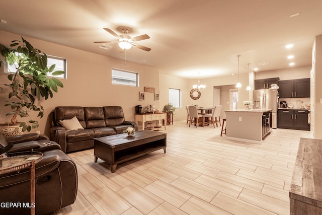 living room featuring ceiling fan with notable chandelier