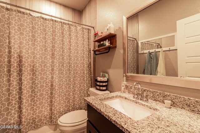 bathroom featuring vanity, toilet, and curtained shower