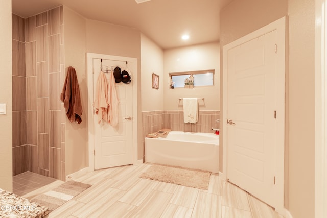 bathroom featuring shower with separate bathtub