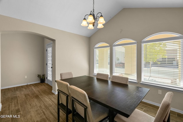 dining area with plenty of natural light, hardwood / wood-style floors, lofted ceiling, and a notable chandelier