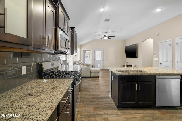 kitchen with dark brown cabinetry, sink, dark hardwood / wood-style floors, vaulted ceiling, and appliances with stainless steel finishes