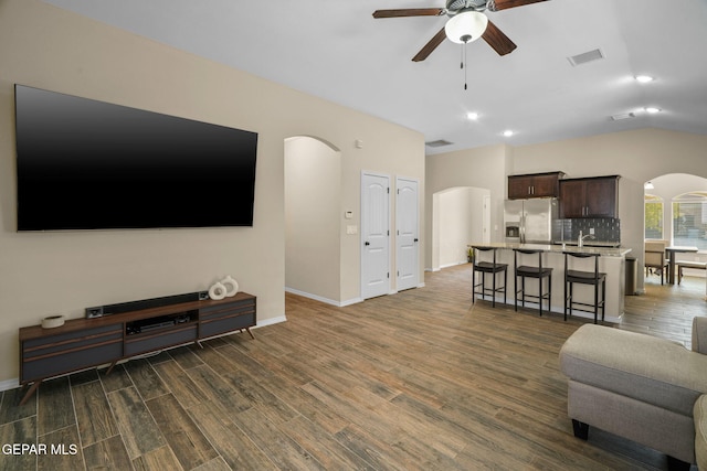 living room with ceiling fan, dark hardwood / wood-style flooring, lofted ceiling, and sink