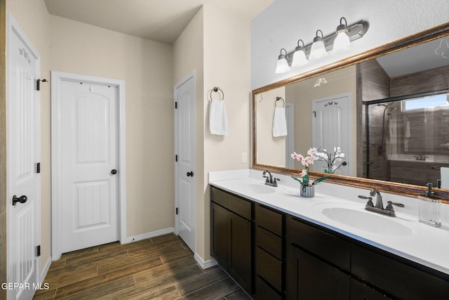 bathroom featuring hardwood / wood-style flooring, vanity, and a shower with door