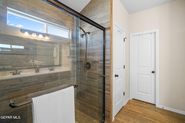 bathroom with wood-type flooring, an enclosed shower, and sink