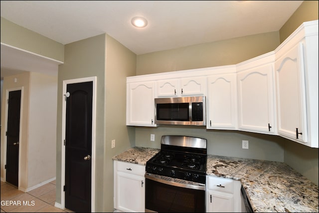 kitchen featuring white cabinets, stainless steel appliances, and light stone countertops