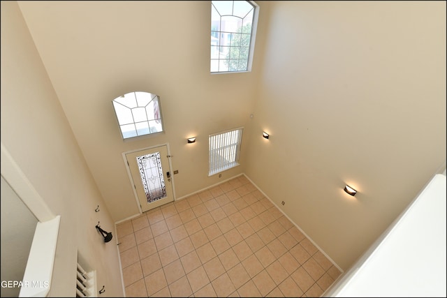 tiled entrance foyer featuring plenty of natural light and a towering ceiling