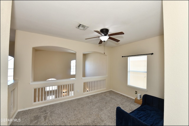 interior space with carpet flooring and ceiling fan