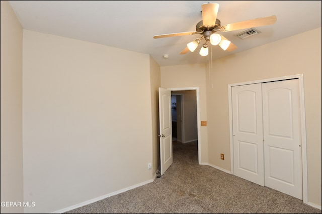 unfurnished bedroom featuring ceiling fan, a closet, and light carpet