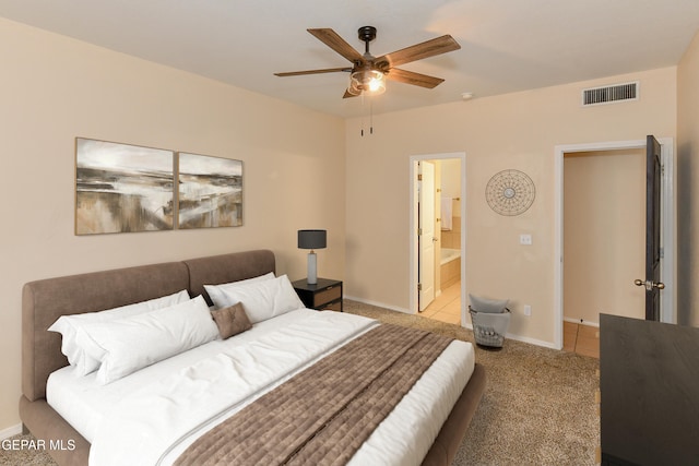 bedroom with ensuite bath, ceiling fan, and light colored carpet