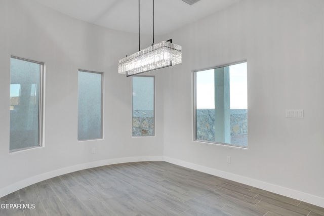 unfurnished room with a towering ceiling and wood-type flooring