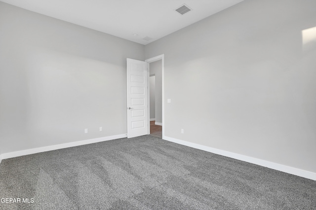 empty room featuring dark colored carpet