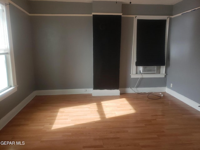 empty room featuring cooling unit and wood-type flooring