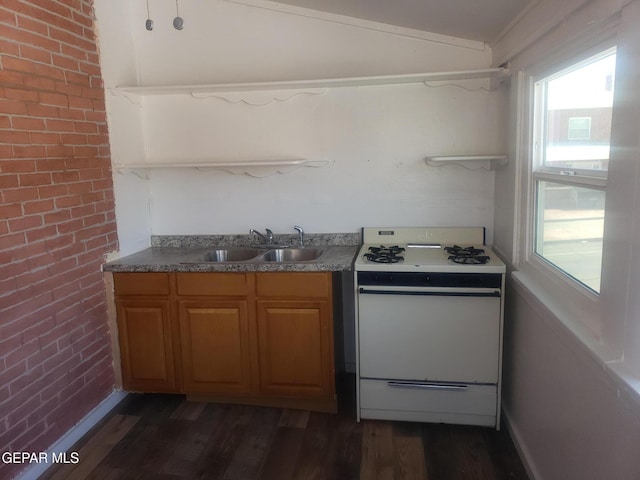 kitchen with dark hardwood / wood-style flooring, brick wall, white range oven, sink, and lofted ceiling