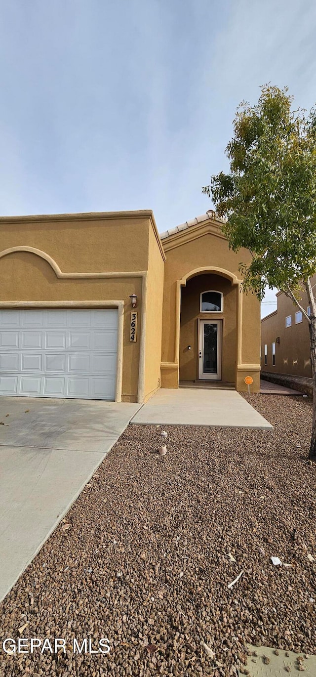 pueblo revival-style home featuring a garage