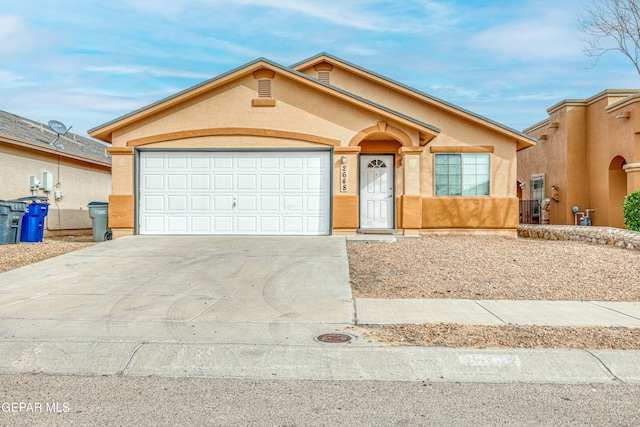 view of front of property with a garage, driveway, and stucco siding