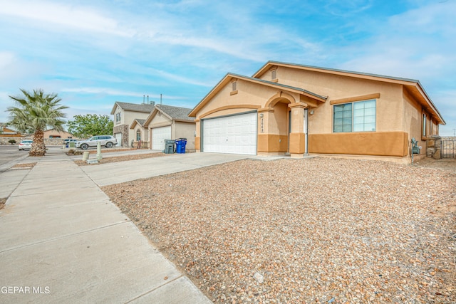 view of front of home with driveway, an attached garage, and stucco siding