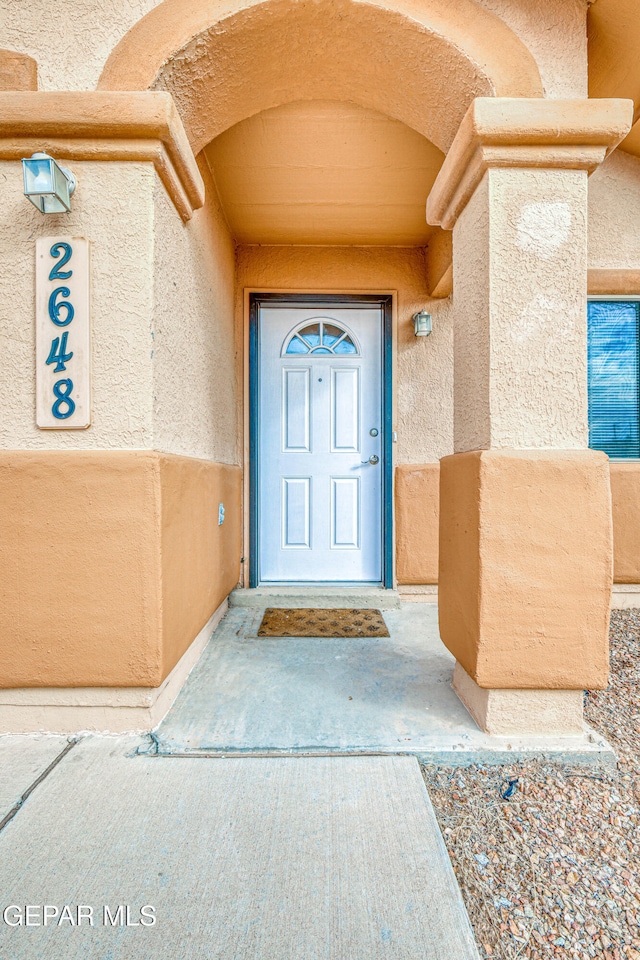 entrance to property featuring stucco siding