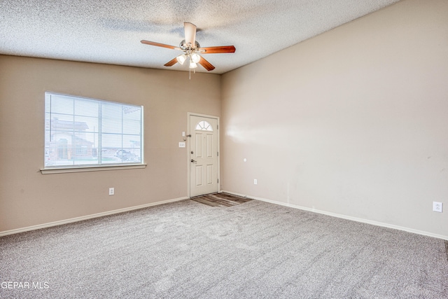 carpeted empty room featuring ceiling fan, a textured ceiling, and baseboards