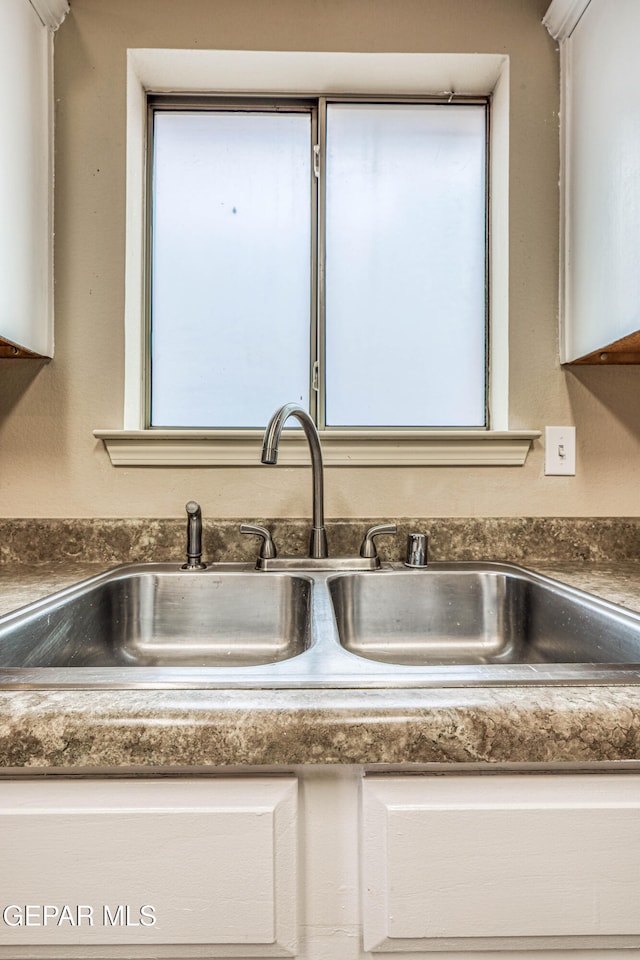 details with a sink and white cabinets