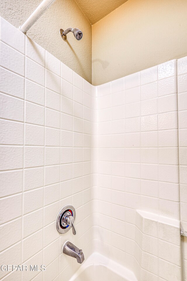 full bath with a textured ceiling and shower / bathing tub combination