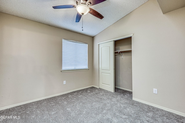 unfurnished bedroom featuring a textured ceiling, baseboards, vaulted ceiling, a closet, and carpet