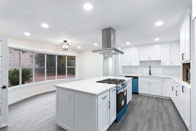 kitchen featuring sink, wall chimney exhaust hood, light hardwood / wood-style floors, white cabinets, and appliances with stainless steel finishes