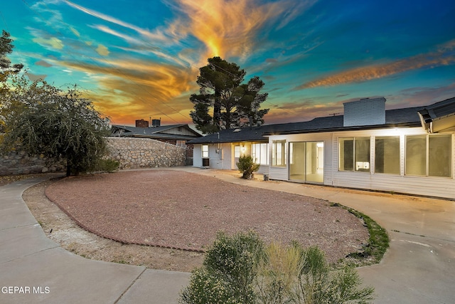 view of back house at dusk