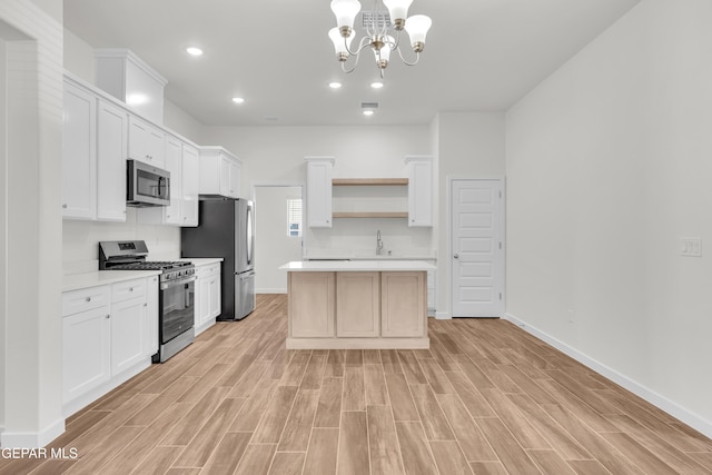 kitchen featuring white cabinets, appliances with stainless steel finishes, and a notable chandelier