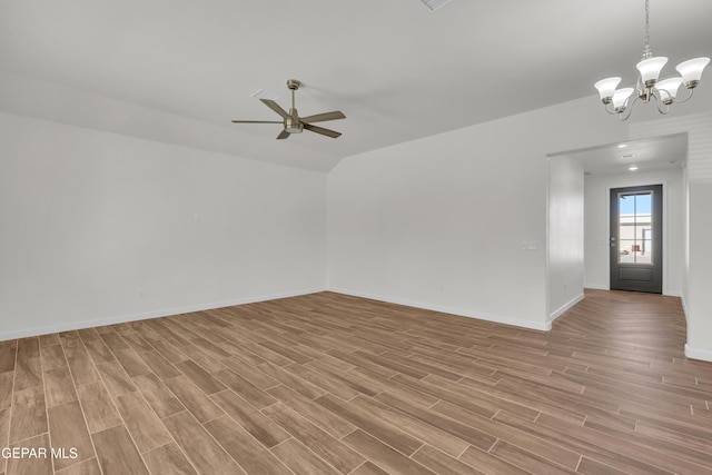 empty room featuring ceiling fan with notable chandelier