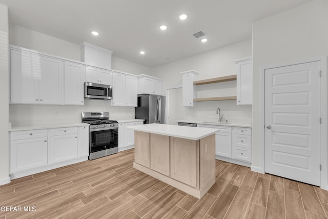 kitchen with a center island, white cabinetry, sink, and appliances with stainless steel finishes